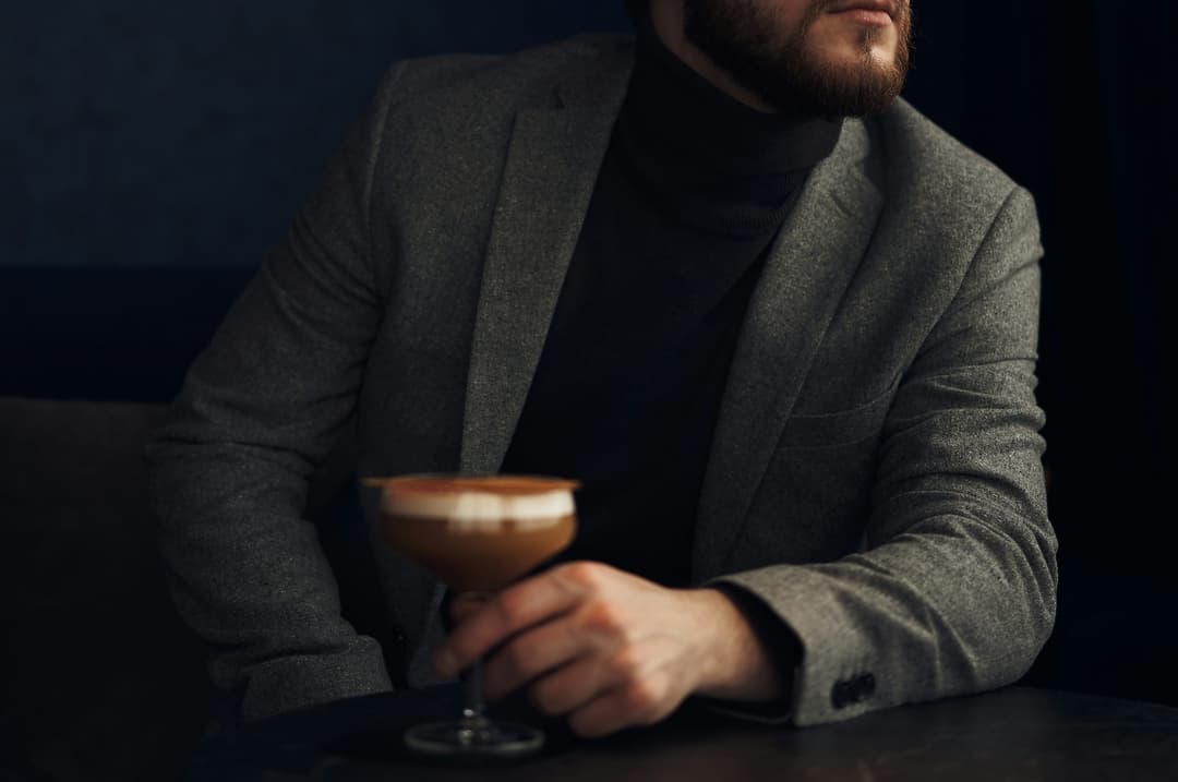 Well-dressed professional enjoying a cocktail in a dimly lit Toronto lounge