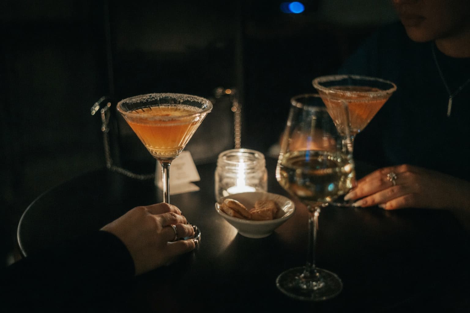 Elegant couple enjoying cocktails in a dimly lit Toronto lounge